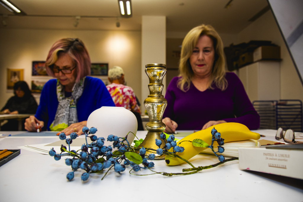 Two individuals looking at objects to draw.